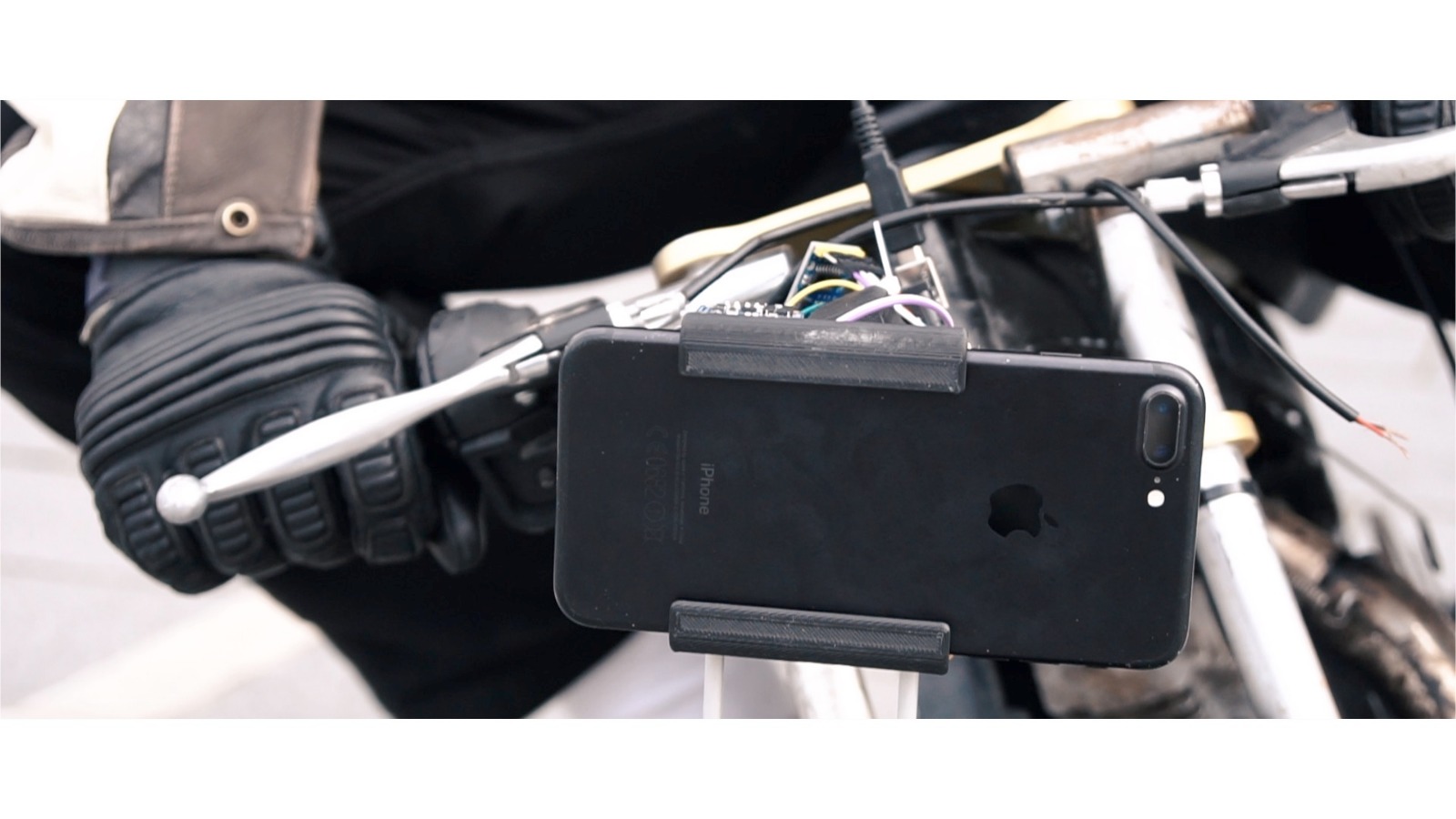 Phone mounted in a prototype rig with exposed electronics.